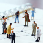 close up of miniature people with social network diagram on open