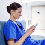 female doctor or nurse with smartphone at hospital