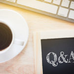 Concept Q&A message on wood boards. A keyboard and a glass coffe