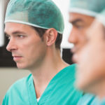 Three surgeons in operating theatre in hospital