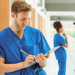 Medical student taking notes in hallway