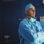 Surgeon standing with arms crossed in operation room