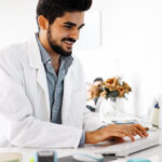 Doctor typing and using his computer